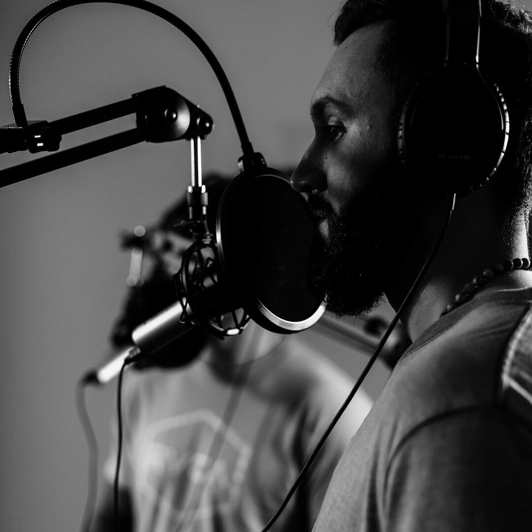 Woman podcast host speaking into a microphone in a recording studio